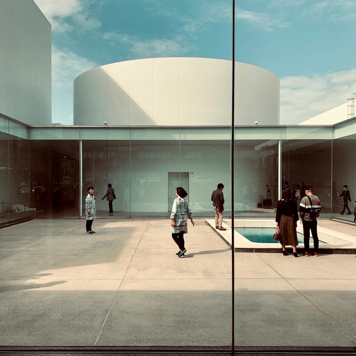 a group of people standing around a pool in a building